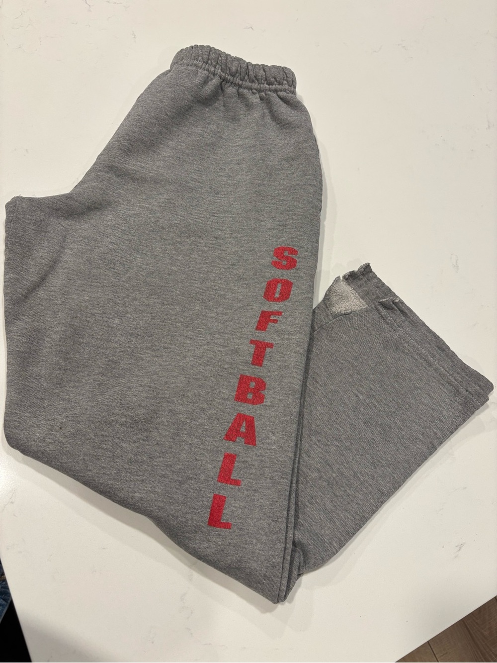 Vintage Gray sweatpants with vertical text reading “SOFTBALL”